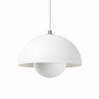 Vit pendellampa med rund metallskärm i modern skandinavisk design.