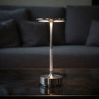 Uppladdningsbar LED bordslampa i metall med modern minimalistisk design och varm belysning på bord i vardagsrum
