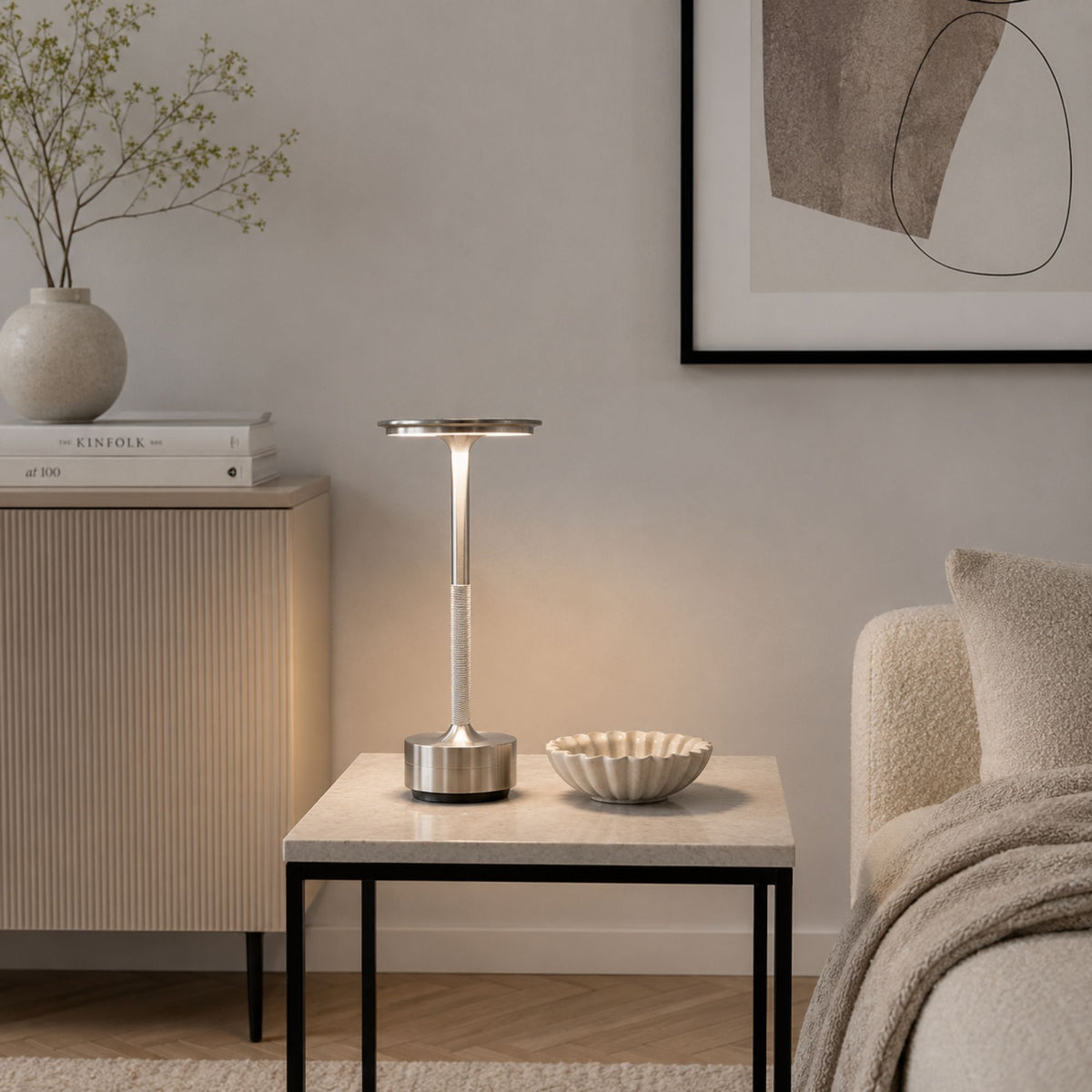 Portabel LED-bordslampa i borstad silverfinish på sidobord i modernt skandinaviskt vardagsrum.