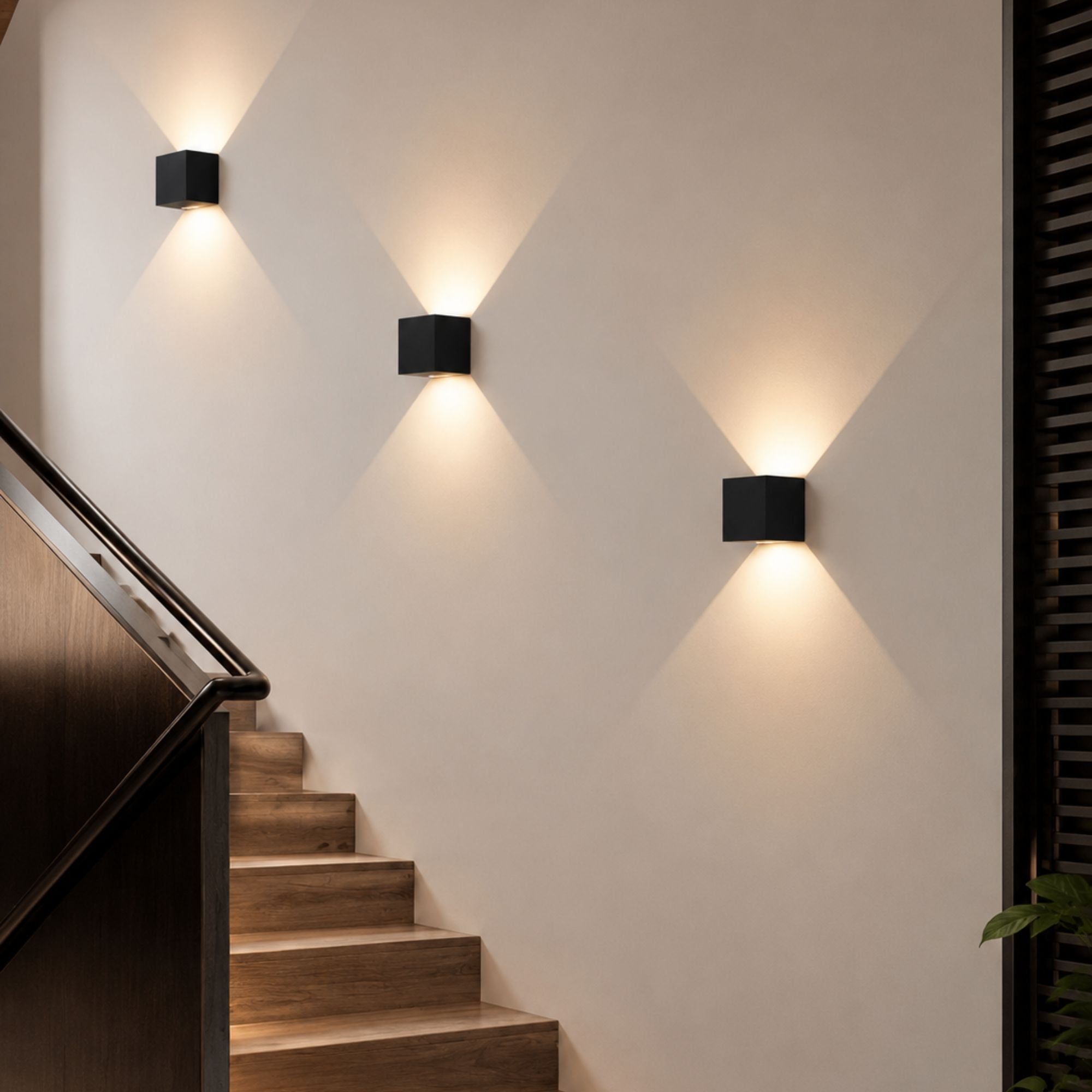 Svarta vägglampor Aura med LED-belysning och rörelsesensor i modernt trapphus.